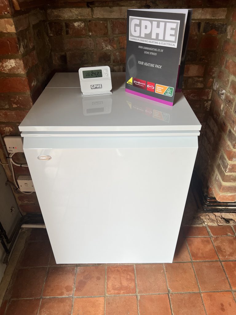Modern white Grant boiler installation in Essex home by Gamma Plumbing Heating & Electrical (GPHE), featuring heating pack and digital thermostat on top.